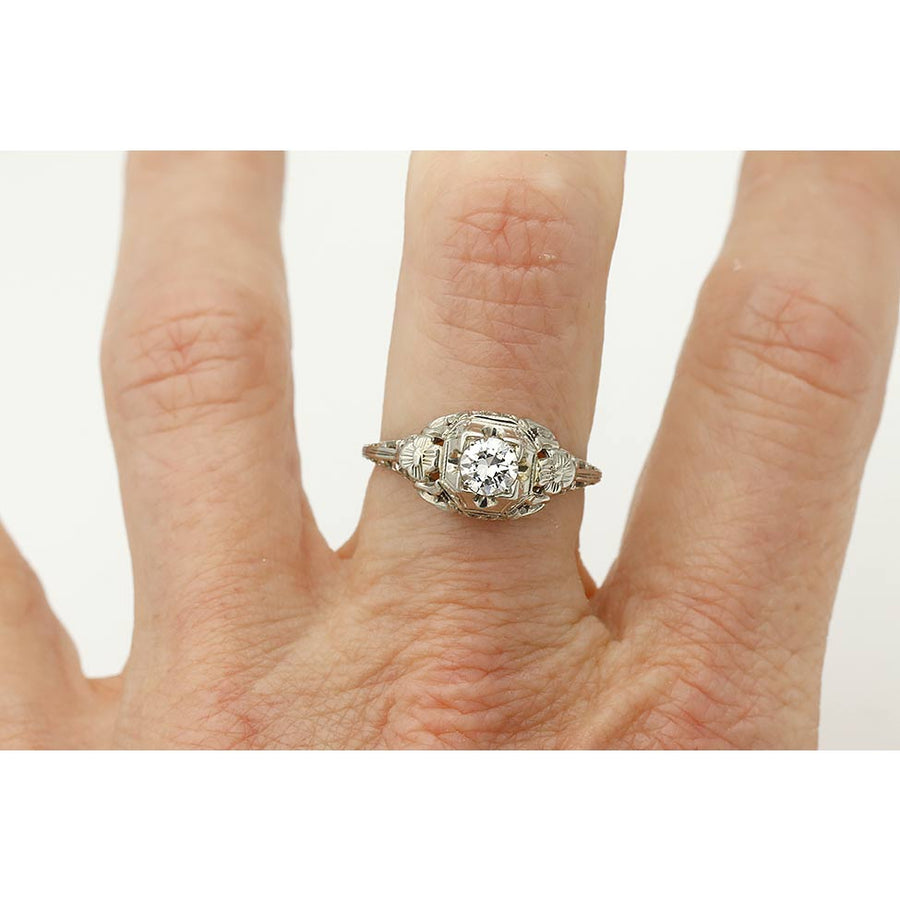 Art Deco .35 ct old European cut diamond engagement ring in 18K white gold with floral engraving and geometric detailing on hand