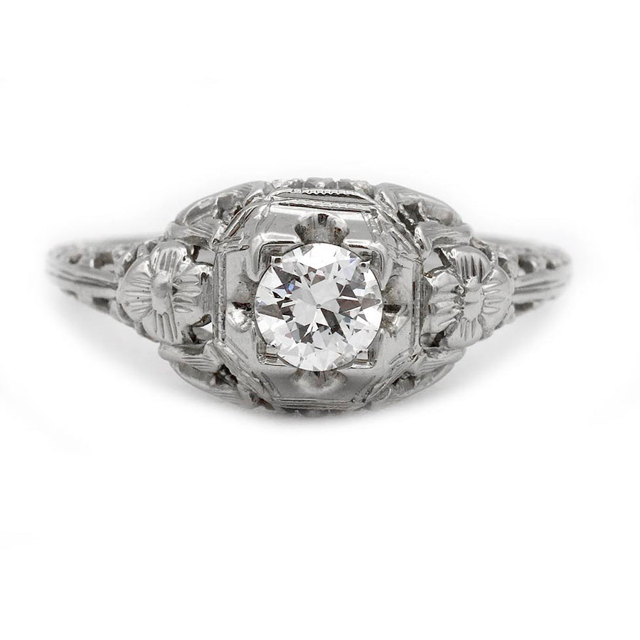 Art Deco old European cut diamond engagement ring in 18K white gold featuring a .35 carat center diamond, geometric square frame, floral engraving, and delicate open metalwork.