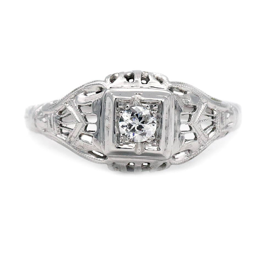 Art Deco old European cut diamond solitaire engagement ring in 18K white gold featuring a geometric square frame, open metalwork, and milgrain engraving.
