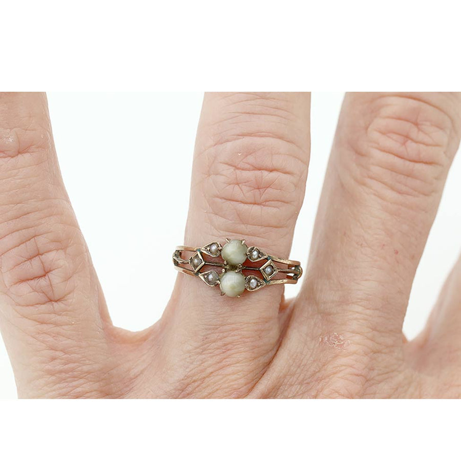 Victorian cat’s eye chrysoberyl and seed pearl engagement ring shown on hand for scale