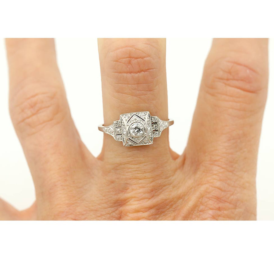 art deco bezel set old european cut diamond engagement ring in 18 kt white gold shown on a finger