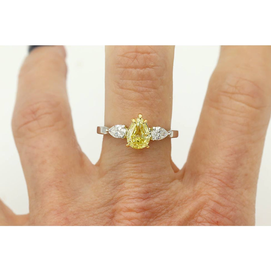 Vintage style canary yellow diamond three stone engagement ring shown on hand