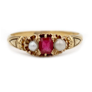 Victorian three-stone engagement ring in 10K rosy-yellow gold featuring a square cut pink garnet doublet, two natural seed pearls, and delicate filigree engraving.